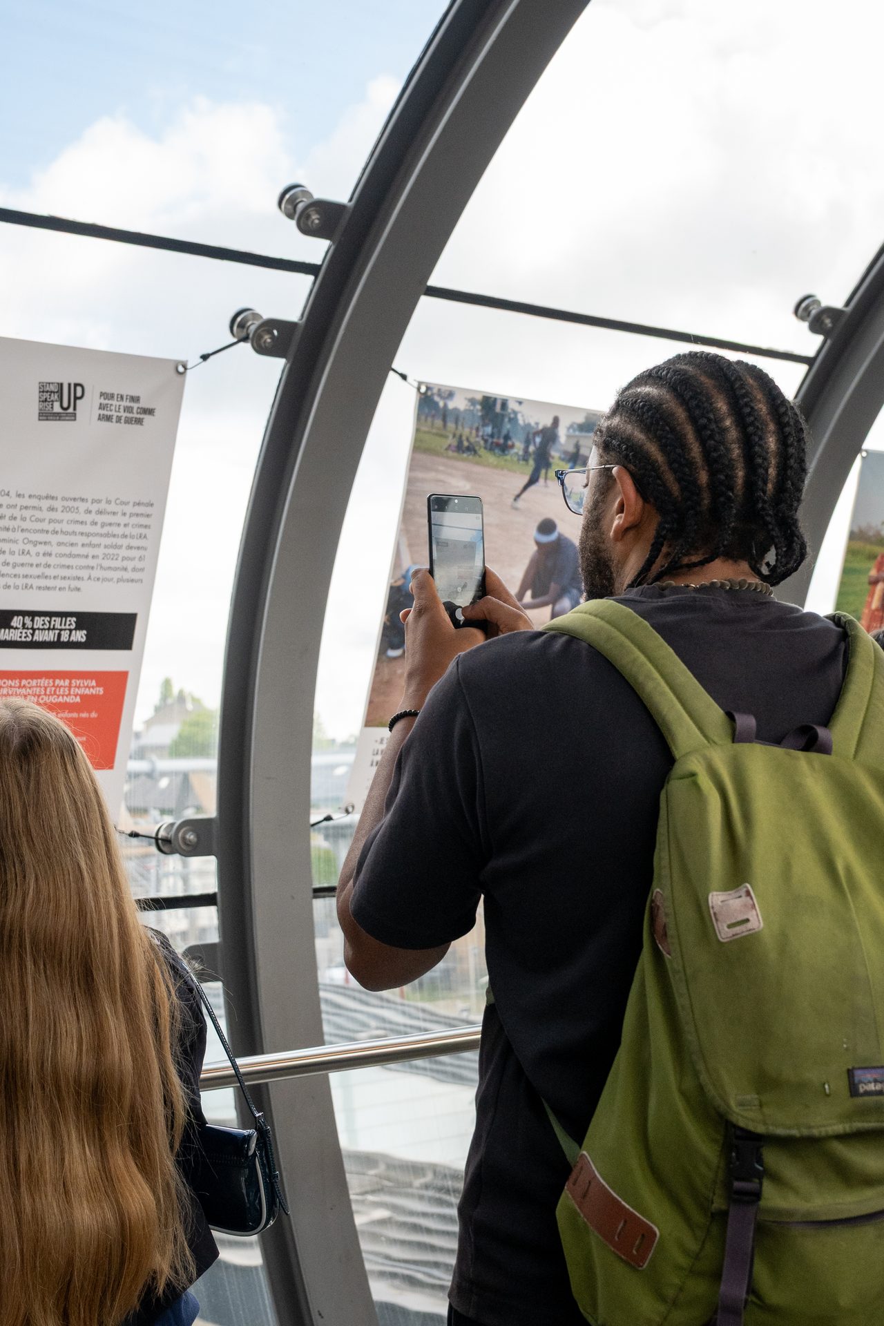 Un visiteur photographie un panneau de l’exposition Simply Survivors