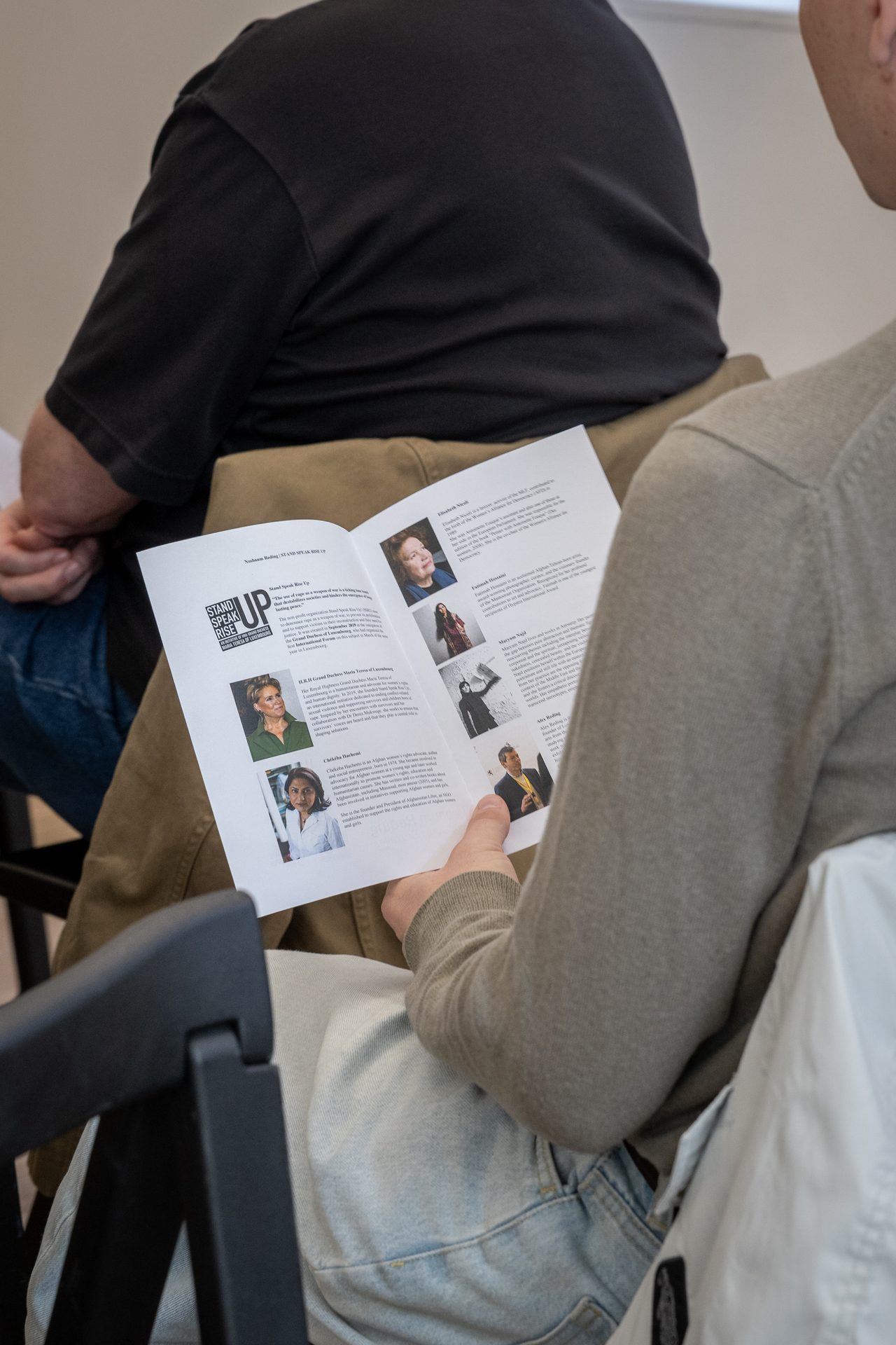 Un participant lit la brochure de Stand Speak Rise Up! lors de la table ronde